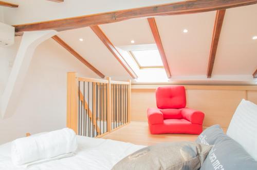 a bedroom with a red chair in a attic at Sunlight Properties - "Legend " - Bright - Near Promenade des Anglais in Nice
