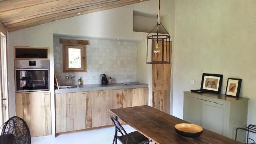 La petite maison في آكس أون بروفانس: مطبخ مع طاولة خشبية وغرفة طعام