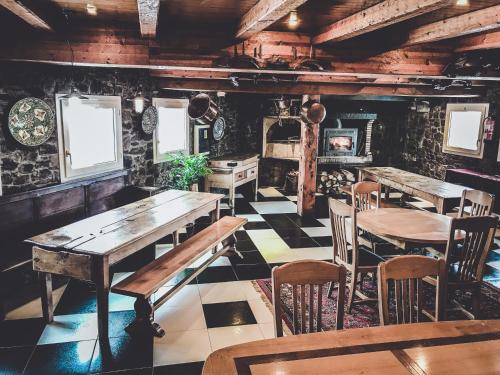 a dining room with tables and chairs and a fireplace at Hotel Llop Gris in El Tarter