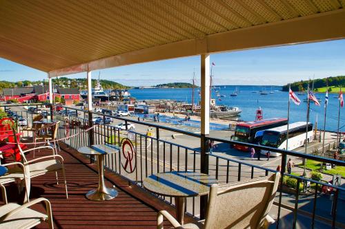 a balcony with tables and chairs and a marina at Rum Runner Inn in Lunenburg