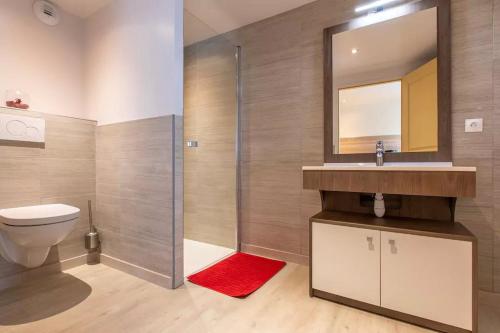 La salle de bains est pourvue de toilettes, d'un lavabo et d'une douche. dans l'établissement Domaine des Ecuries - Appartements meublés à Talloires, à Talloires