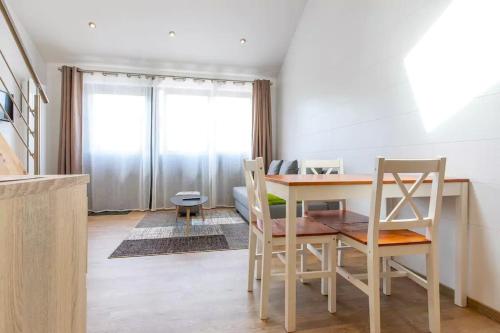 a dining room with a table and chairs in a room at Domaine des Ecuries - Appartements meublés à Talloires in Talloires