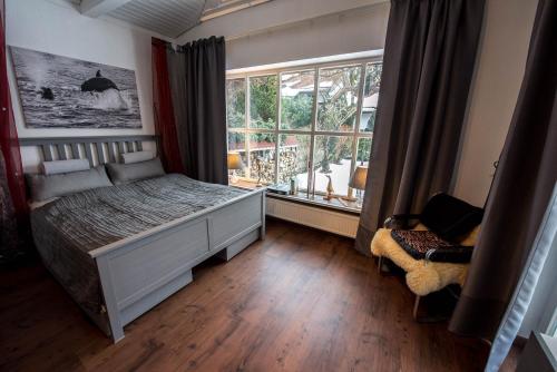 1 dormitorio con cama y ventana grande en München- Pullach, Wohnen im Grünen, en Pullach im Isartal