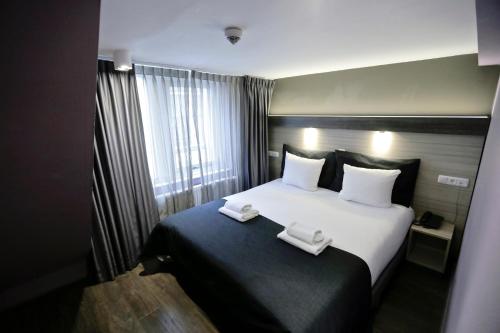 a hotel room with a bed with two towels on it at City Hotel Amsterdam in Amsterdam