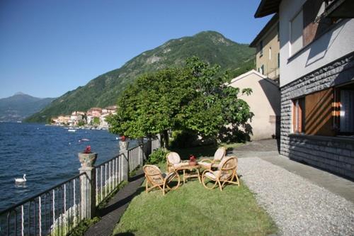 a patio with a table and chairs next to the water at Bellagio Villas in Lezzeno