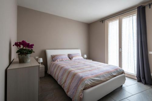 sypialnia z łóżkiem i dużym oknem w obiekcie Casa Mari Fronte Lago w mieście Salò