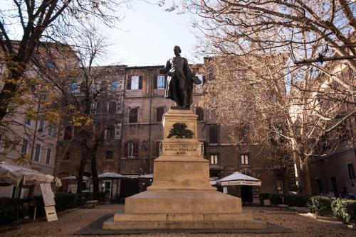 a statue of a man on a pedestal in front of a building at Navona Queen Rooftop in Rome