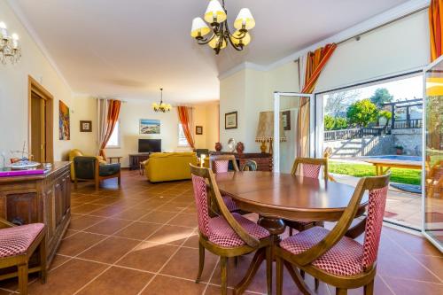 a living room with a wooden table and chairs at Villa Amarela in Boliqueime