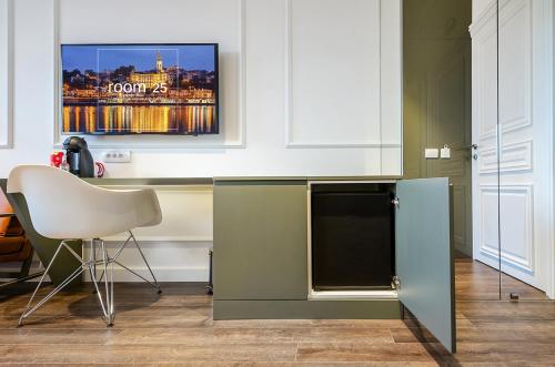 a kitchen with a tv and a chair in a room at Room 25 Belgrade in Belgrade