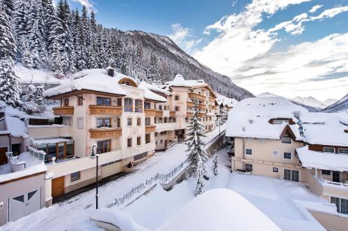 una ciudad en las montañas cubierta de nieve en Alpvita Piz Tasna, en Ischgl