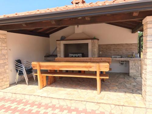 a wooden bench on a patio with a fireplace at Guesthouse Pejo in Poreč