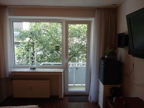 a room with a window with a view of a tree at CityMinis in Düsseldorf