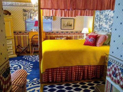 ein Schlafzimmer mit einem Bett mit einer gelben Decke in der Unterkunft Shamrock Thistle & Crown B&B in Weirsdale