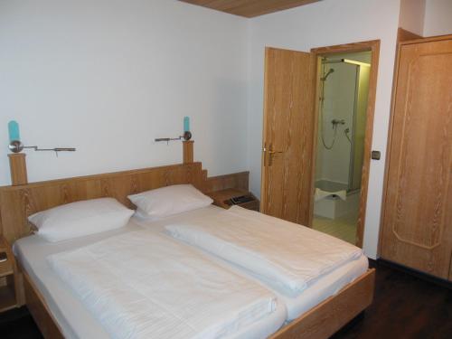 a bedroom with a bed and a bathroom with a shower at Hotel & Restaurant Zum Ochsen -Ox Distillery in Hösbach