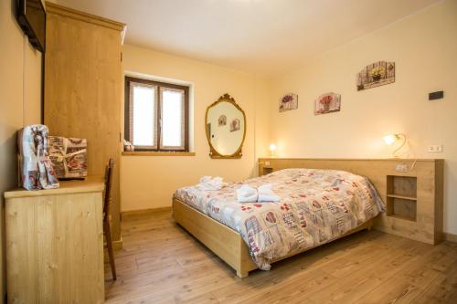 a bedroom with a bed and a mirror on the wall at Alloggio del contadino in Sondrio