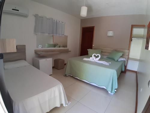 a room with two beds and a mirror at Atobá Villas in Paraty