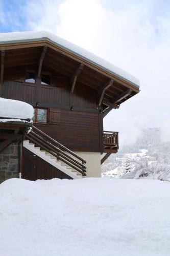 a building with snow on the ground in front of it at La Résidence de L'Ours in Megève