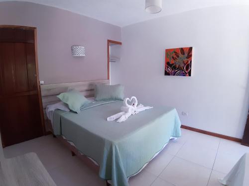un dormitorio con una cama con un animal de peluche en Atobá Villas, en Paraty