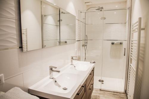 Un baño blanco con lavabo y ducha. en Appartement Gialla, en Porto Vecchio