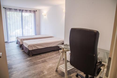 Un dormitorio con dos camas y un escritorio y una silla. en Appartement Gialla, en Porto Vecchio