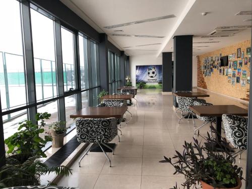 a restaurant with tables and chairs and windows at Olympic Sport in Podgortsy