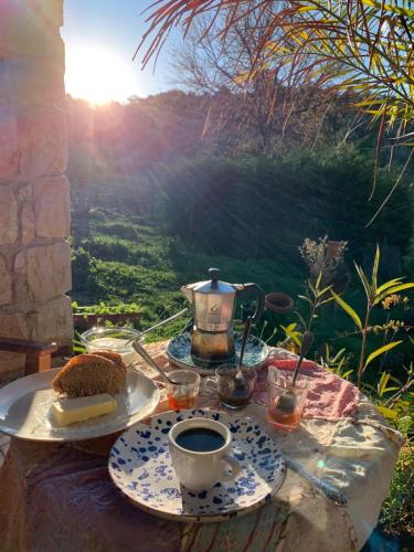 una mesa con un plato de pastel y una taza de café en place in paradise, en Castelbuono