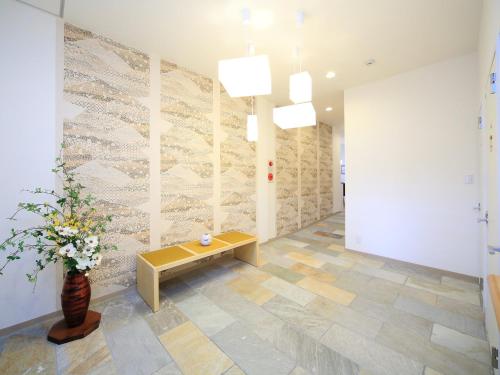 a lobby with a bench and a vase of flowers at カモンイン 東寺東 in Kyoto