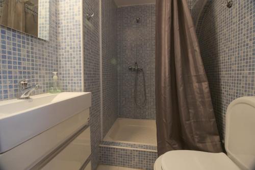 a bathroom with a sink and a shower with a toilet at Tavira Downtown Calm House in Tavira