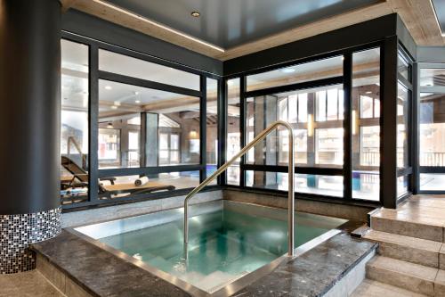 a hot tub in a room with windows at Residence Anitea in Valmorel