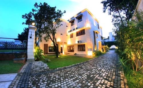 a white building on a cobblestone street at Forever City Hotel in Kiribathgoda