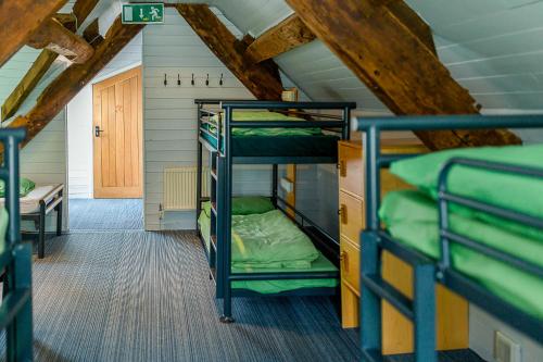 a room with three bunk beds in a house at YHA Hartington Hall in Hartington