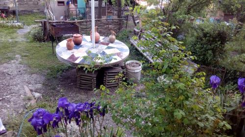 a garden with a table with vases on it at Guest House Khatuna in Borjomi