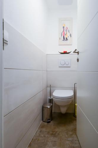 a white bathroom with a toilet and a sink at Apartmenthaus Vergissmeinnicht in Abtenau
