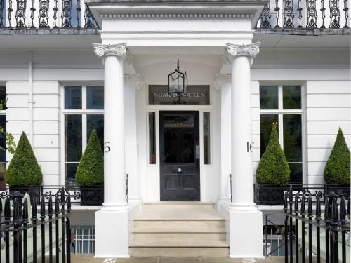 a white house with a black door and columns at Number Sixteen, Firmdale Hotels in London