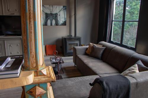 Una sala de estar con un sofá y un televisor. en Boutique Logement Londen Centrum Middelburg, en Middelburg