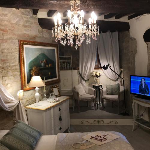 a living room with a chandelier and a tv in it at Residenza Teatro Antico in Todi
