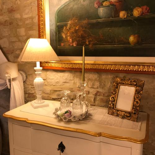 a table with a lamp and a picture on it at Residenza Teatro Antico in Todi