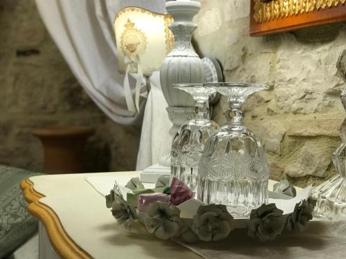 a table with two glass vases and flowers on it at Residenza Teatro Antico in Todi