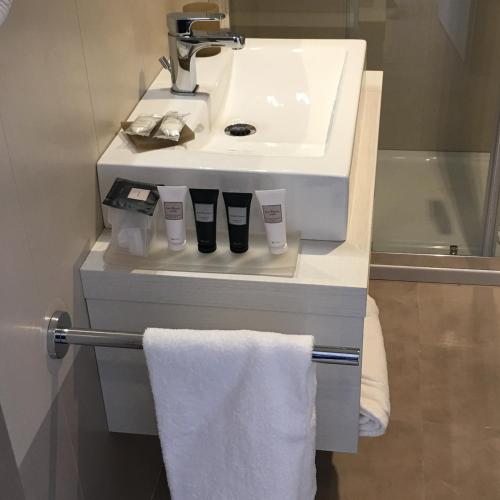 a bathroom with a sink and a white towel at Hotel Stele di Nora in Pula