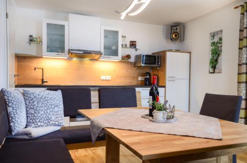 a living room with a table and a kitchen at Apartmenthaus Vergissmeinnicht in Abtenau