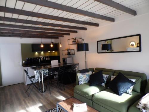 uma sala de estar com um sofá verde e uma mesa em Pra Loup Appart'hotel em Pra-Loup