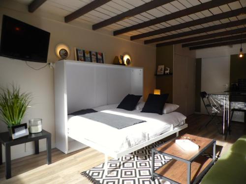 - une chambre avec un lit blanc et une télévision dans l'établissement Pra Loup Appart'hotel, à Pra-Loup