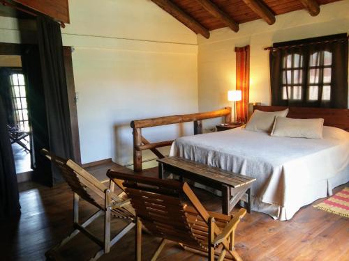 1 dormitorio con 1 cama, mesa y sillas en la matilda en Santa Rosa de Calamuchita