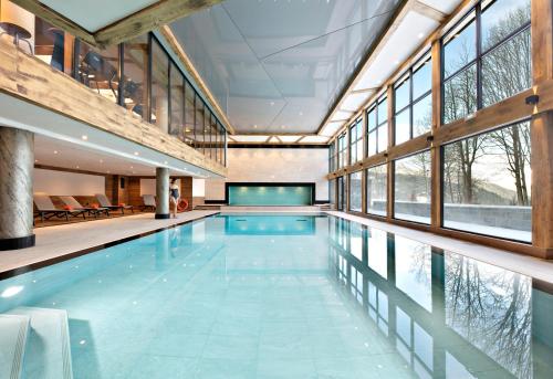 an indoor swimming pool with a large room with windows at Les Chalets Elena in Les Houches