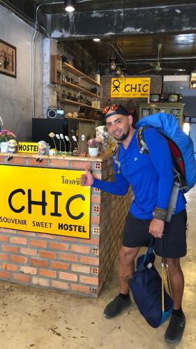 a man with a backpack standing in front of a store at OK CHIC PHUKET HOSTEL in Phuket Town