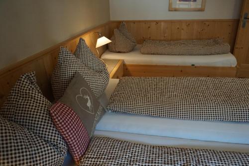 two beds with checkered pillows in a room at Appartement Schmid in Oetz