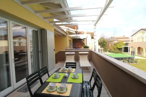 un patio con 2 tavoli e sedie su un balcone di Appartamenti Acquadolce a Peschiera del Garda