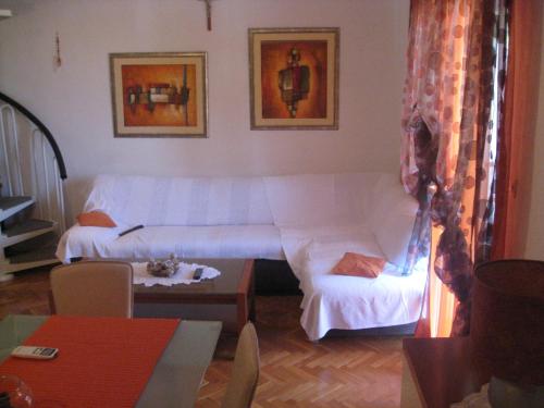 a living room with a white couch and a table at Villa Volga in Jelsa