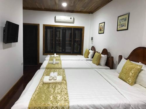 a group of four beds in a room at Elephant Boutique Hotel in Luang Prabang