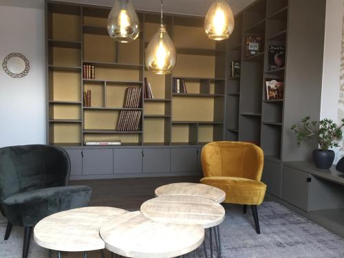 a room with two chairs and a table and shelves at Chambres d'hôtes L'Ecrin des Saveurs in Schwenheim